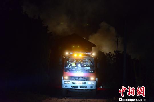 花炮厂外停放着消防车，车后依然浓烟滚滚。 杨华峰 摄