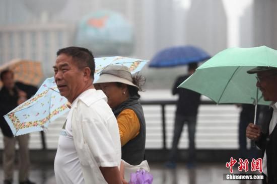 上海外滩只有零星小雨，观光台上的一些游客们甚至没有撑伞。张亨伟 摄