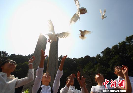 在烈士纪念碑前，孩子们放飞了象征和平的白色鸽子。　李珂 摄