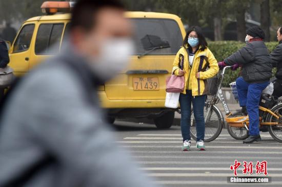 北京街头市民佩戴口罩出行。 中新网记者 金硕 摄