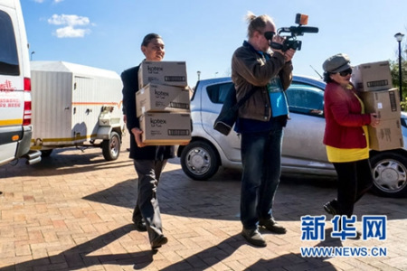 8月4日，中国驻开普敦总领事康勇(左一)在搬运捐赠品。 新华网发(琳达·伊摄)
