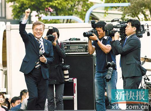  ■5月6日，韩国共同民主党总统候选人文在寅（左一）在竞选活动上向支持者挥手示意。
